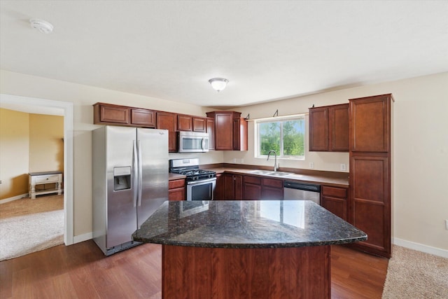 14704 Crescent Meadows Dr, Cedar Springs, MI 49319 - kitchen with appliances with stainless steel finishes, dark stone counters, dark wood-style flooring, and a kitchen island