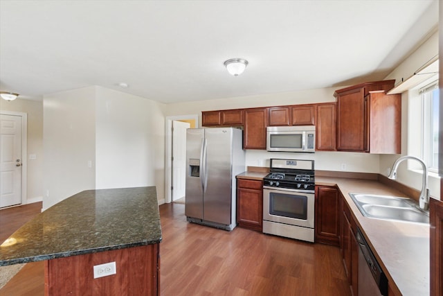 14704 Crescent Meadows Dr, Cedar Springs, MI 49319 - kitchen with stainless steel appliances, wood finished floors, a center island, and dark stone counters