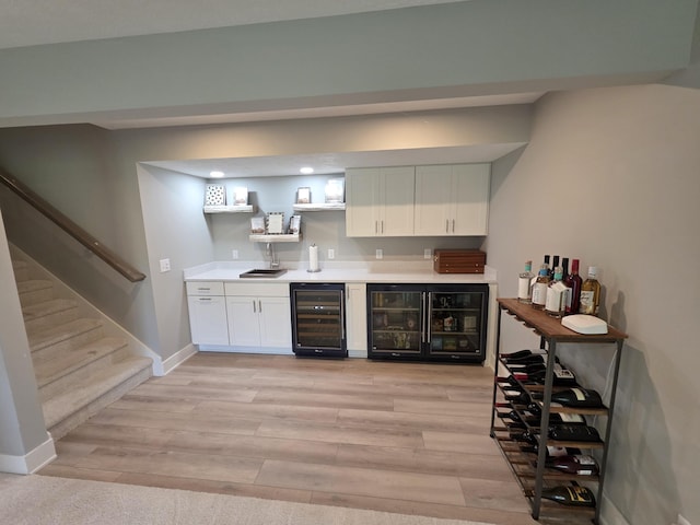 3076 Brayridge Dr, Jenison, MI 49428 - indoor wet bar featuring beverage cooler, light wood finished floors, stairs, and recessed lighting