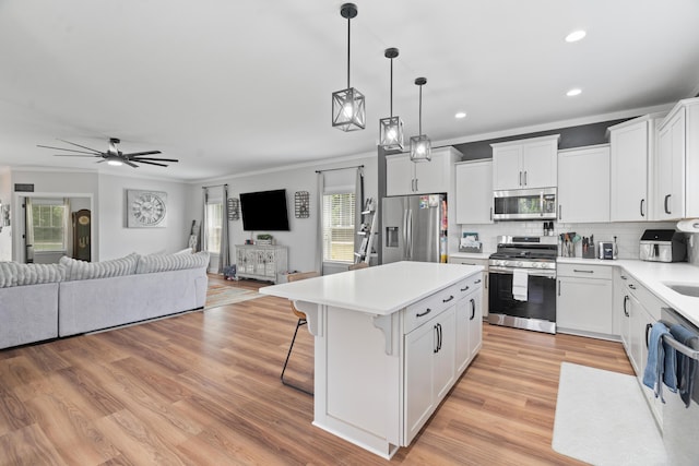 14846 Portage Rd, Vicksburg, MI 49097 - kitchen with stainless steel appliances, open floor plan, crown molding, a center island, and a kitchen bar