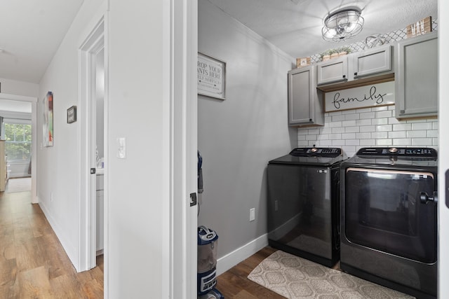 14846 Portage Rd, Vicksburg, MI 49097 - washroom featuring cabinet space, washer and dryer, and wood finished floors