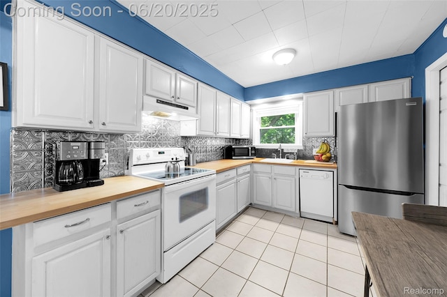 22410 Glen Ct, Saint Clair Shores, MI 48080 - kitchen featuring appliances with stainless steel finishes, wood counters, under cabinet range hood, and tasteful backsplash