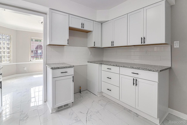 5766 Nottingham Rd, Detroit, MI 48224 - kitchen with light marble finish floors, light stone countertops, backsplash, and white cabinetry