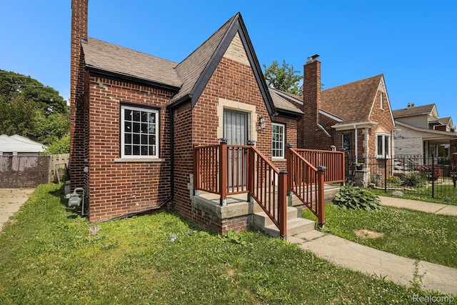 5766 Nottingham Rd, Detroit, MI 48224 - tudor-style house with brick siding, a chimney, and a shingled roof