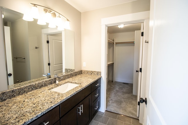 11449 Hidden Oaks Dr, Clio, MI 48420 - bathroom with vanity, a walk in closet, and tile patterned floors