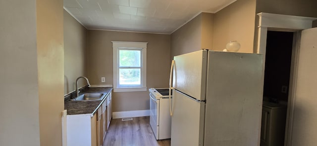 2524 8th St, Muskegon, MI 49444 - kitchen featuring white appliances, dark countertops, light wood-style floors, and ornamental molding