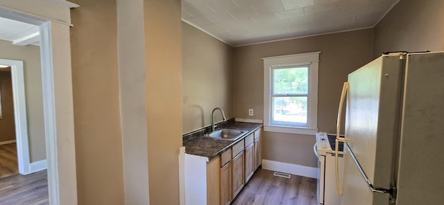 2524 8th St, Muskegon, MI 49444 - kitchen with white appliances, light wood-style flooring, dark countertops, and ornamental molding