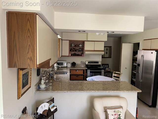 5408 Vincennes Dr, Bloomfield Hills, MI 48302 - kitchen featuring appliances with stainless steel finishes, a peninsula, under cabinet range hood, open shelves, and light stone countertops