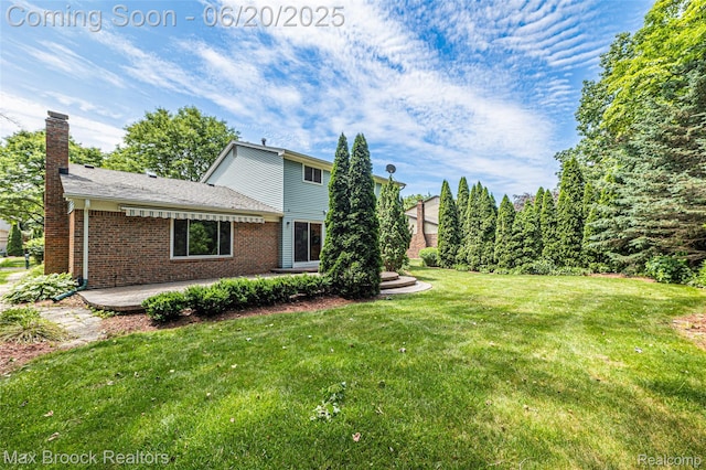 683 Thurber Dr, Troy, MI 48085 - view of property exterior featuring a patio, a chimney, a lawn, and brick siding