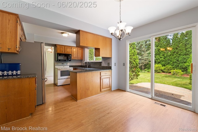 683 Thurber Dr, Troy, MI 48085 - kitchen with white electric stove, black microwave, a peninsula, light wood-style flooring, and a chandelier