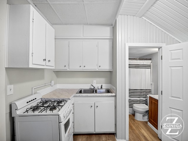 1044 Kenneth St, Muskegon, MI 49442 - kitchen featuring white gas range oven, light wood-style flooring, white cabinets, and light countertops