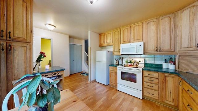 3126 Bolgos Cir, Ann Arbor, MI 48105 - kitchen featuring white appliances, light wood-type flooring, dark countertops, and tasteful backsplash