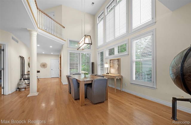 6510 Commerce Rd, West Bloomfield, MI 48324 - dining space featuring a high ceiling, light wood-type flooring, and decorative columns