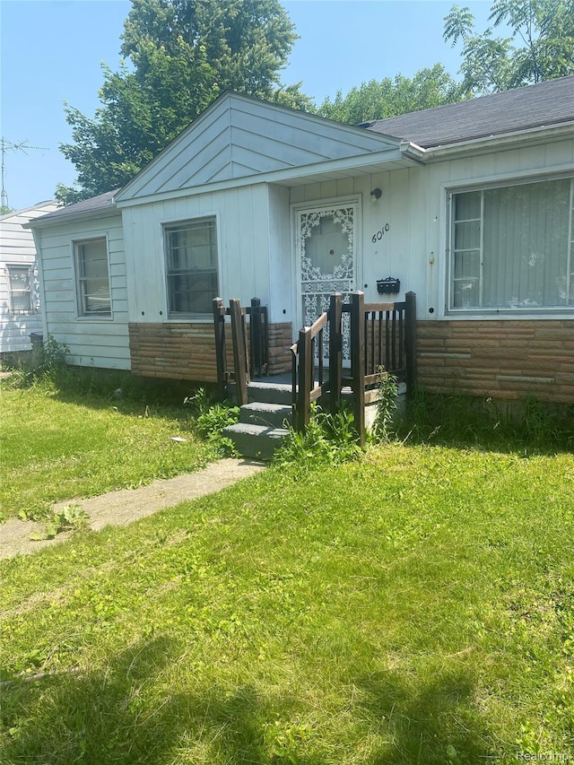 6010 Marja St, Flint, MI 48505 - view of front facade featuring board and batten siding and a front yard