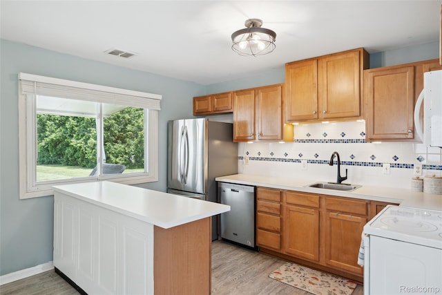 39248 Wade Rd, Taylor, MI 48174 - kitchen with stainless steel dishwasher, white microwave, light wood-style floors, and backsplash