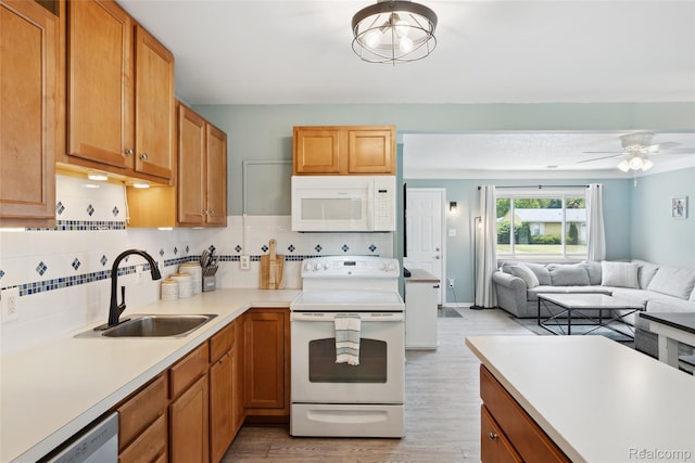 39248 Wade Rd, Taylor, MI 48174 - kitchen featuring white appliances, light wood-type flooring, decorative backsplash, light countertops, and ceiling fan