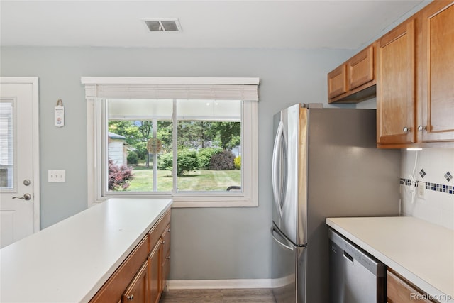 39248 Wade Rd, Taylor, MI 48174 - kitchen featuring dishwasher, light countertops, brown cabinetry, backsplash, and wood finished floors