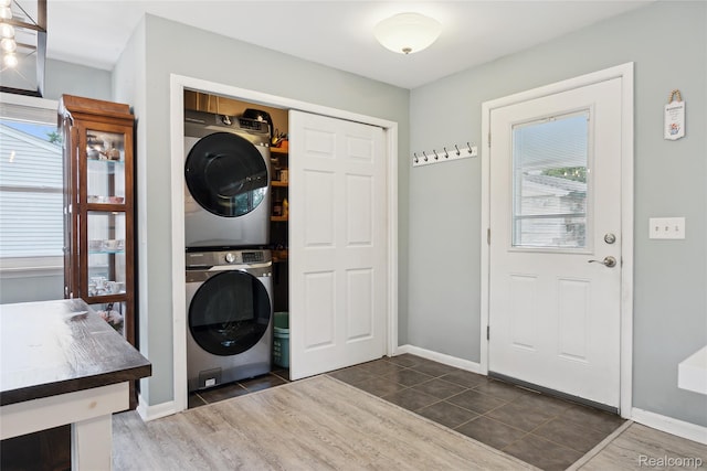 39248 Wade Rd, Taylor, MI 48174 - washroom with stacked washing machine and dryer, healthy amount of natural light, and dark tile patterned flooring