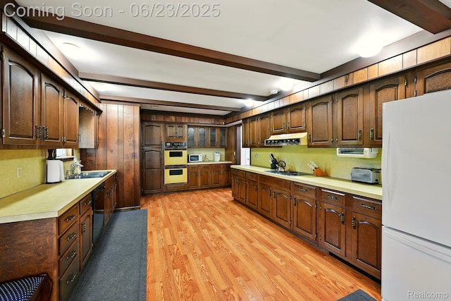 2441 Cheryl Ann Dr, Burton, MI 48519 - kitchen with white appliances, light countertops, light wood-style flooring, beam ceiling, and under cabinet range hood