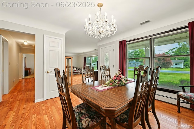 2441 Cheryl Ann Dr, Burton, MI 48519 - dining room featuring light wood-type flooring, a chandelier, and a baseboard radiator