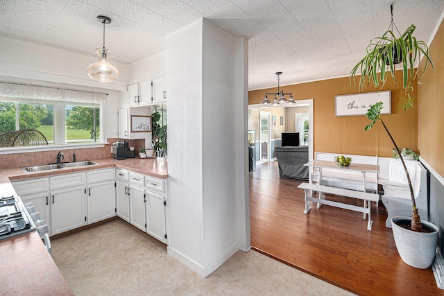 14711 White Creek Ave NE, Cedar Springs, MI 49319 - kitchen featuring light countertops, white cabinetry, stove, hanging light fixtures, and light wood finished floors