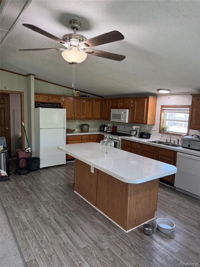 27444 Bordeau Dr, Romulus, MI 48174 - kitchen featuring white appliances, a textured ceiling, light countertops, dark wood-type flooring, and a center island