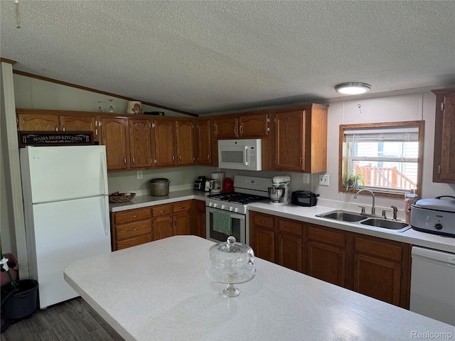 27444 Bordeau Dr, Romulus, MI 48174 - kitchen with white appliances, vaulted ceiling, a textured ceiling, wood finished floors, and light countertops