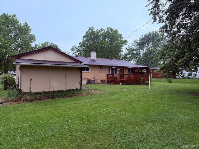 906 W Burnside St, Caro, MI 48723 - back of house with a wooden deck, a yard, a chimney, and brick siding