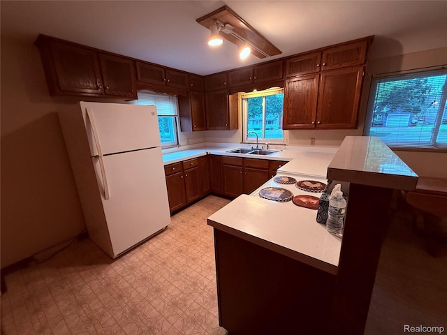 906 W Burnside St, Caro, MI 48723 - kitchen featuring freestanding refrigerator, light countertops, a peninsula, and light floors