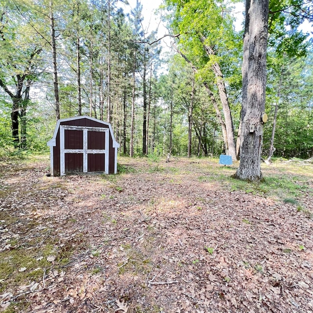 6539 Mattis Dr, Glennie, MI 48737 - view of yard with a storage shed and a forest view