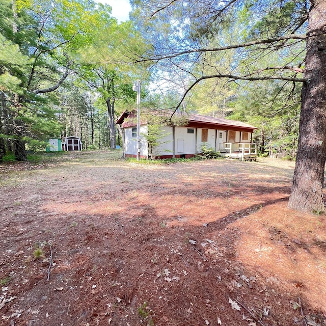 6539 Mattis Dr, Glennie, MI 48737 - view of front of house with covered porch and a shed