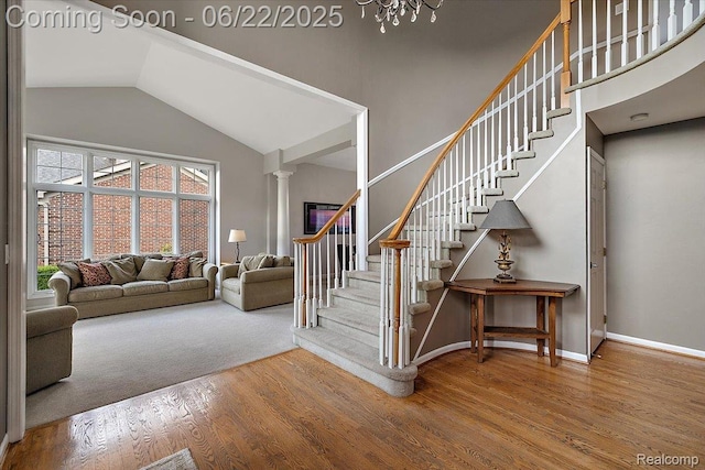 11700 Currin Ct, Plymouth, MI 48170 - stairway featuring wood finished floors, high vaulted ceiling, ornate columns, and a chandelier
