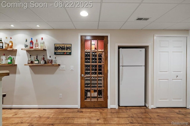 11700 Currin Ct, Plymouth, MI 48170 - indoor dry bar featuring freestanding refrigerator, wood finished floors, a paneled ceiling, and recessed lighting