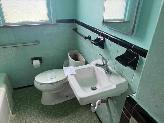 18908 Mackay St, Detroit, MI 48234 - bathroom featuring tile walls, a bathtub, and wainscoting