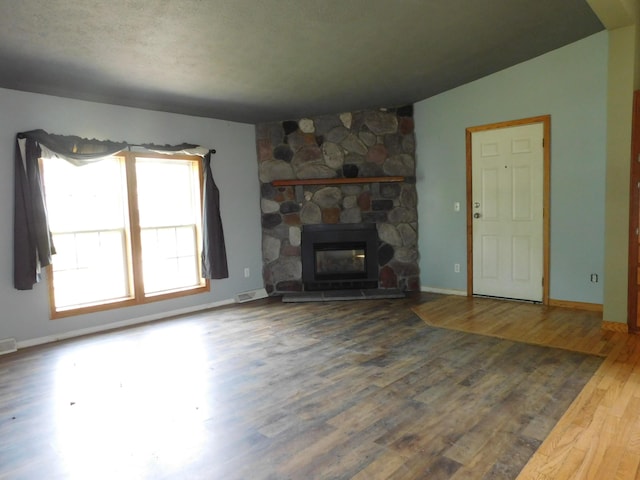 1240 Abbey Ln, Mount Pleasant, MI 48858 - unfurnished living room with wood finished floors and a stone fireplace