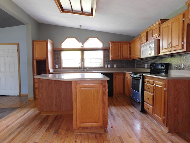 1240 Abbey Ln, Mount Pleasant, MI 48858 - kitchen featuring stainless steel electric range, white microwave, lofted ceiling, light countertops, and a center island