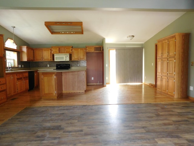 1240 Abbey Ln, Mount Pleasant, MI 48858 - kitchen featuring white microwave, vaulted ceiling, range, black dishwasher, and a center island