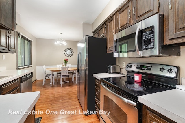 5178 Mangrove Dr, Saginaw, MI 48603 - kitchen featuring stainless steel appliances, light countertops, light wood-style floors, and dark brown cabinetry