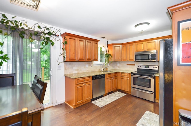 3851 Mapleleaf Rd, Waterford, MI 48328 - kitchen featuring appliances with stainless steel finishes, dark wood finished floors, decorative backsplash, and light stone countertops