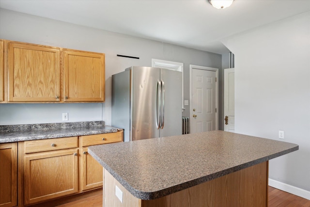 402 Ann Arbor St, Manchester, MI 48158 - kitchen with freestanding refrigerator, dark countertops, wood finished floors, and a center island