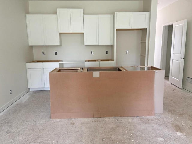 1968 S Shorewood Ln, Holland, MI 49423 - kitchen featuring a center island, white cabinets, and light colored carpet