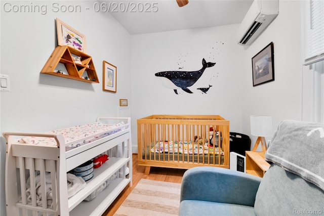 2429 Holmes St, Hamtramck, MI 48212 - bedroom with a wall mounted AC, wood finished floors, and a crib