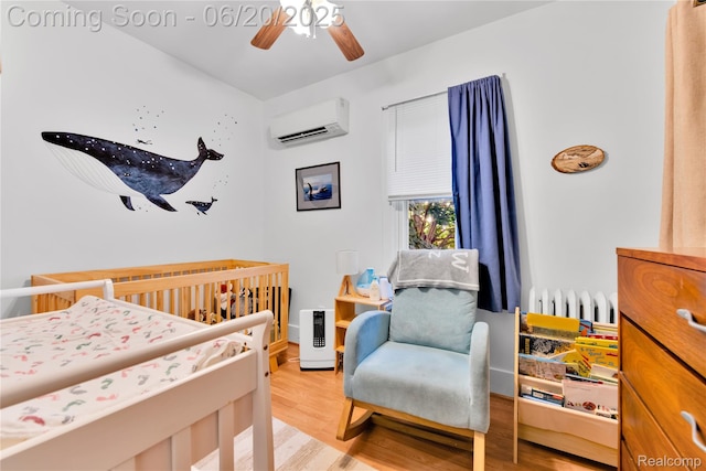 2429 Holmes St, Hamtramck, MI 48212 - bedroom with a wall mounted air conditioner, a crib, wood finished floors, radiator heating unit, and a ceiling fan
