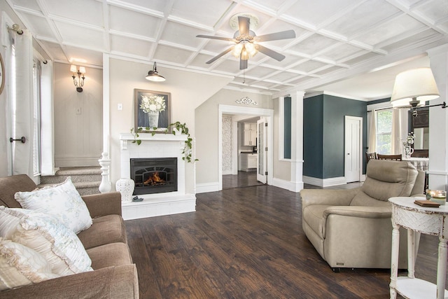 105 Clark St, Buchanan, MI 49107 - living area featuring ceiling fan, coffered ceiling, wood finished floors, a glass covered fireplace, and decorative columns