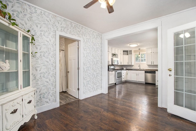 105 Clark St, Buchanan, MI 49107 - kitchen featuring appliances with stainless steel finishes, wallpapered walls, dark wood-style flooring, crown molding, and dark countertops