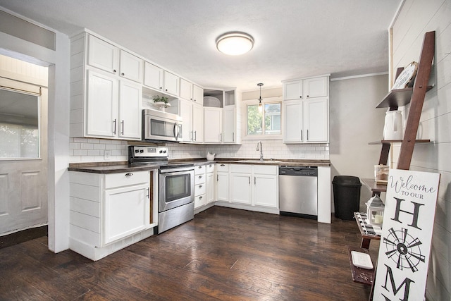 105 Clark St, Buchanan, MI 49107 - kitchen featuring stainless steel appliances, dark countertops, tasteful backsplash, and dark wood-style floors