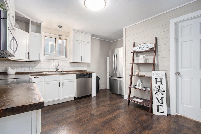 105 Clark St, Buchanan, MI 49107 - kitchen with appliances with stainless steel finishes, butcher block counters, tasteful backsplash, dark wood finished floors, and white cabinetry