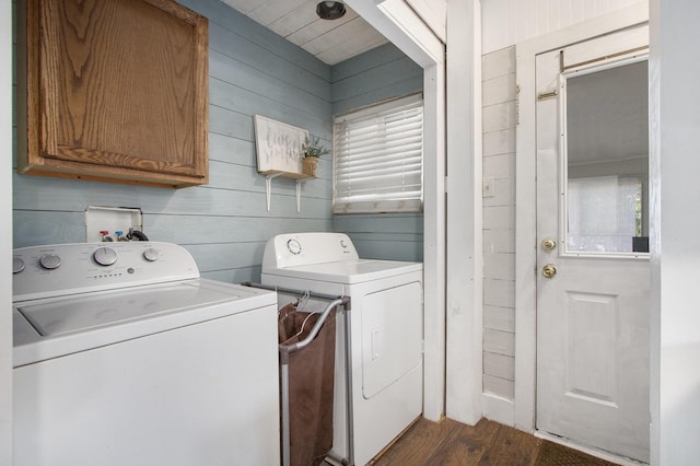 105 Clark St, Buchanan, MI 49107 - laundry area with washer and dryer, dark wood-style floors, wood walls, and cabinet space