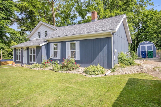207 E Jefferson St, Cassopolis, MI 49031 - view of front facade featuring a shingled roof, a front yard, and a shed