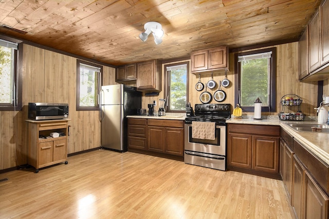 207 E Jefferson St, Cassopolis, MI 49031 - kitchen featuring stainless steel appliances, wooden ceiling, light wood-type flooring, wood walls, and light countertops